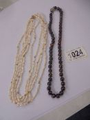 A five strand pearl necklace with a 14k gold clasp and one other necklace.