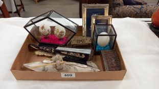 A tray of miscellaneous including silver plated photo frames, painted eggs, fan an Inuit Eskimo in