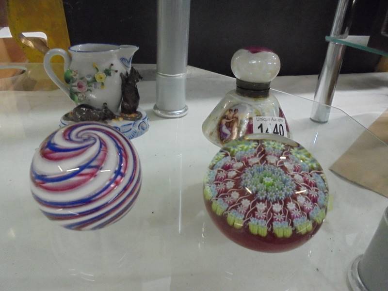 A millifiori paperweight, another paperweight, a scent bottle and a jug.
