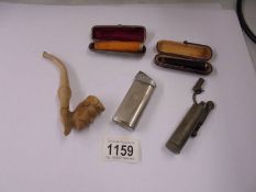 A cheroot holder in silver case, one other, a clay pipe and two cigarette lighters.