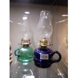 A Bristol blue glass and a green glass finger oil lamps.