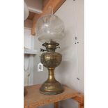 A Victorian oil lamp with embossed brass base and original etched shade. COLLECT ONLY.