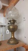 A Victorian oil lamp with embossed brass base and original etched shade. COLLECT ONLY.