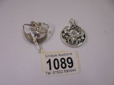 A silver art nouveau style brooch and a silver pendant.