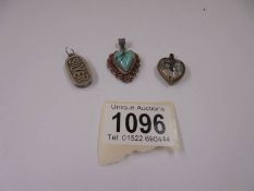 A silver heart pendant, a quarter ounce silver ingot pendant and a royalty heart pendant.