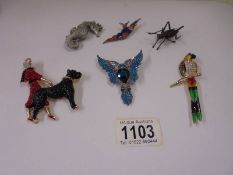 An enamel/diamonte parrot brooch, a woman walking a dog brooch, a pheonix brooch and three others