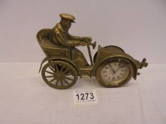 A vintage brass clock in the form of a veteran car with Toby Baxter movement, in working order.