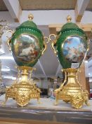 A pair of continental porcelain lidded urns with gilded bases and fittings, COLLECT ONLY.