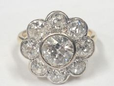 An 18ct round cluster ring set with a round brilliant cut diamond surrounded by 8 old cut diamonds,
