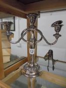 A silver plate candelabra, small silver trophy and silver sugar tongs.
