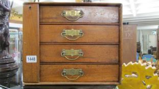 A small oak four drawer chest with brass handles. COLLECT ONLY.