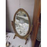 An oval framed swivel mirror, COLLECT ONLY.