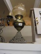 An old oil lamp on cast base with brass font. COLLECT ONLY.
