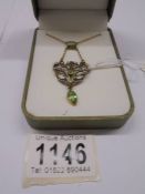 An Edwardian pendant set with pearls and green stones in yellow/white metal.