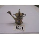 An antique porcelain and white metal (possibly silver) miniature watering can, marks indistinct,