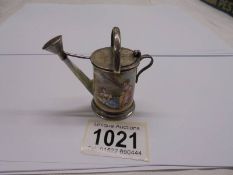 An antique porcelain and white metal (possibly silver) miniature watering can, marks indistinct,