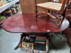 A dark wood stained oval extending dining table COLLECT ONLY