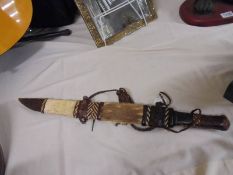 A tribal hunting knife in sheath,