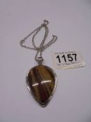 A banded jasper pendant and chain in silver.