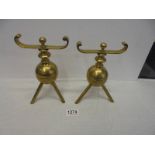 A pair of brass Christopher Dresser fire dogs.