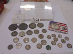 A collection of silver coins including American Eagle silver dollar.