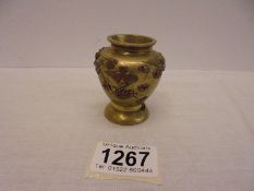 A 19th century brass vase decorated with relief copper flowers, 6.5 cm tall.