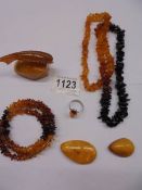 An amber necklace, amber bracelet, amber set ring, amber fish on rock and two amber stones.