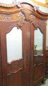 A heavily carved mahogany French armoire, COLLECT ONLY.