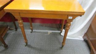 A light oak fold over games table on castors, COLLECT ONLY.