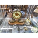 An old brass clock in working order but missing one hand and glass together with another brass clock