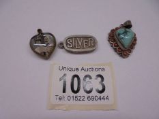 Three silver pendants, two heart and one ingot.