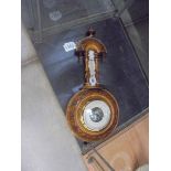 A small wall hanging barometer/thermometer.