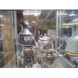 A silver plate teapot, water jug and two milk jugs.