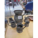 A large old pewter tankard and five miniature pewter tankards.