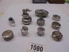 A silver pill box with elephant atop and a collection of silver plate pill boxes.