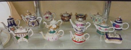 Twelve miniature teapots and three other items.
