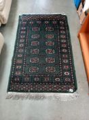 An old green wool rug, 80cm x 135cm COLLECT ONLY