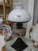 A late Victorian oil lamp on cast iron base with glass font and shade, no damage to glass, COLLECT