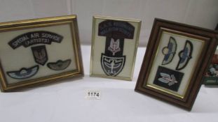 Three framed and glazed sets of cloth badges.