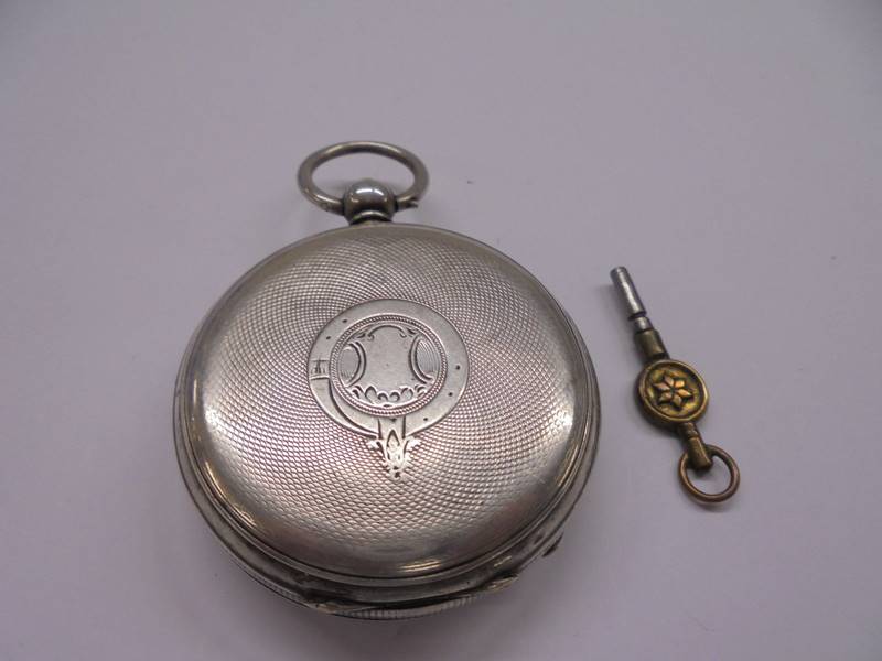 A silver pocket watch with key, in working order. - Image 2 of 3