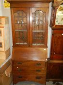 An arts and crafts oak bureau bookcase (glass in one door a/f), COLLECT ONLY.