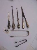 Two silver sugar tongs, 2 silver handled button hooks, silver handled glove stretchers etc.,