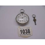 A silver pocket watch with key, in working order.