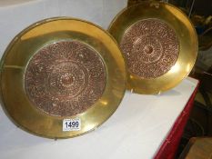 A pair of copper footed bowls with brass centres.