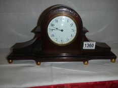 A mahogany mantel clock in working order.