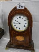 A mahogany inlaid arched top mantel clock. In working order.