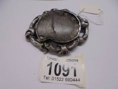 A 19th century ammonite fossil brooch in a chased silver mount.