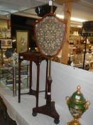 A Victorian mahogany pole screen with embroidered shield shaped panel. COLLECT ONLY.