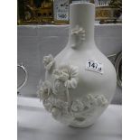 A Parian style ceramic vase with applied flowers.