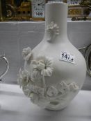 A Parian style ceramic vase with applied flowers.